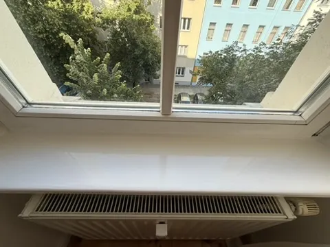 Neu aufgearbeitete weiße Fensterbank über dem Heizkörper.