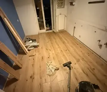 Verlegter Mehrschicht-Holzboden in der Küche, mit noch bereitliegendem Werkzeug.